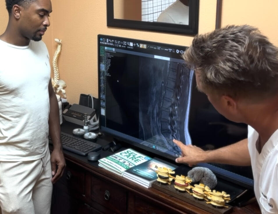 Santa Clarita chiropractor reviewing spine scan with patient Santa Clarita chiropractor Dr. Thomas Polucki discussing a lumbar spine scan with a patient during a consultation