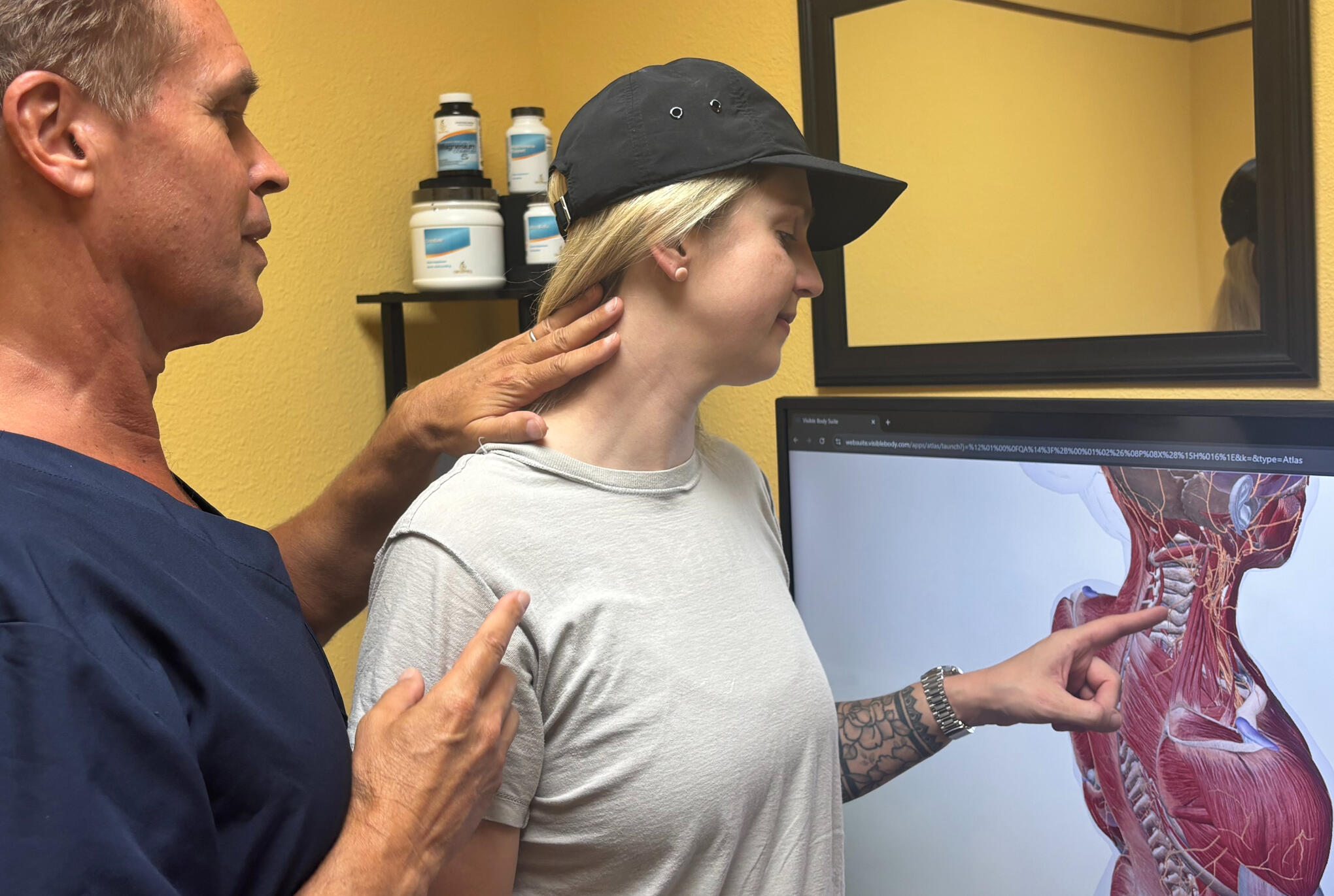 Santa Clarita chiropractor reviewing spine scan with patient Santa Clarita chiropractor Dr. Thomas Polucki explaining connection between neck and shoulder pain.